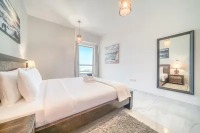 a bedroom with a large bed and a large window at 300m From The Beach - JBR Apartment with Sea & Dubai Eye Views in Dubai