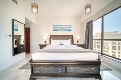 a bedroom with a large bed and large windows at 300m From The Beach - JBR Apartment with Sea & Dubai Eye Views in Dubai