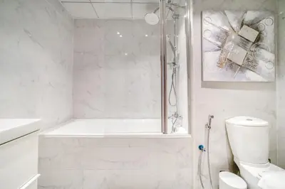 a white bathroom with a shower and a toilet at 300m From The Beach - JBR Apartment with Sea & Dubai Eye Views in Dubai