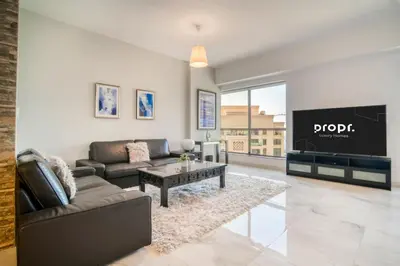 a living room with a couch and a tv at 300m From The Beach - JBR Apartment with Sea & Dubai Eye Views in Dubai