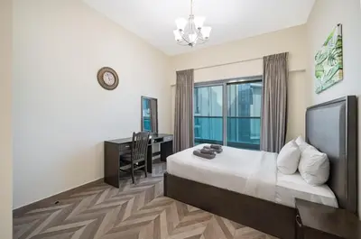a bedroom with a bed and a desk and a window at Family-Sized 4BR Pool, Jacuzzi & Gym in Dubai