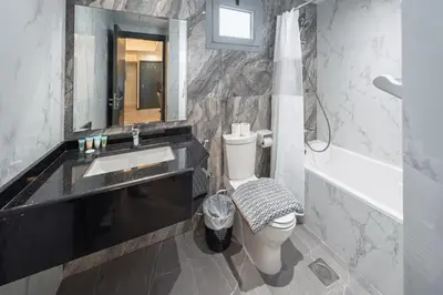 a bathroom with a sink and a toilet and a mirror at Family-Sized 4BR Pool, Jacuzzi & Gym in Dubai