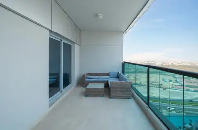 a balcony with a couch and a table at Family-Sized 4BR Pool, Jacuzzi & Gym in Dubai