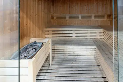 a sauna with wooden floors and a glass wall at Family-Sized 4BR Pool, Jacuzzi & Gym in Dubai