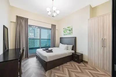 a bedroom with a bed and a desk and a window at Family-Sized 4BR Pool, Jacuzzi & Gym in Dubai