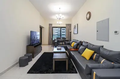 a living room with a couch and a tv at Spacious 4BR En-Suite Apt I Gym, Pool & Parking in Dubai