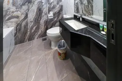 a bathroom with a toilet and a sink and a mirror at Spacious 4BR En-Suite Apt I Gym, Pool & Parking in Dubai