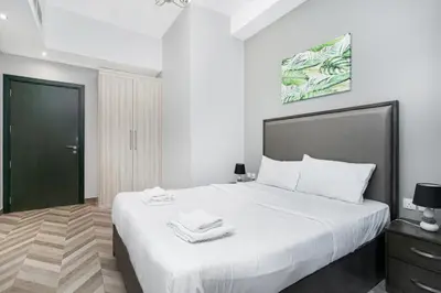 a bedroom with a large white bed with a black headboard at Cozy Family Apt Canal Vista Near Dubai Mall in Dubai