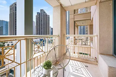 a balcony with a chair and a view of the city at Silkhaus cozy central studio in Downtown in 29 Boulevard in Dubai