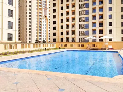 a large swimming pool with buildings in the background at STYLISH 2 BEDROOM SERVICE APARTMENT with SEA VIEW in Dubai
