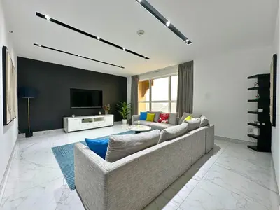 a living room with a couch and a tv at STYLISH 2 BEDROOM SERVICE APARTMENT with SEA VIEW in Dubai