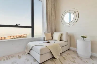 a living room with a chair and a window at The Smart Concierge - Palm tower in Dubai