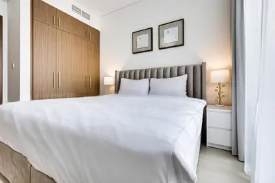a bedroom with a large white bed with two lamps at Sea View 2BD in new 52 42 tower Dubai Marina in Dubai