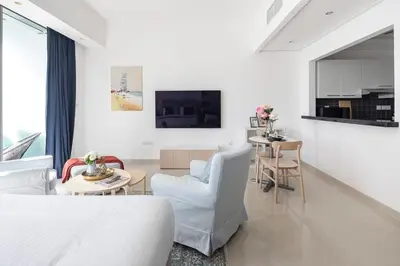 a white living room with a couch and a table at Frank Porter - Silverene Tower B in Dubai