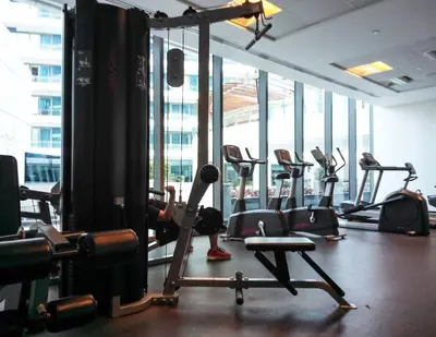 a gym with rows of exercise equipment in a building at Frank Porter - Silverene Tower B in Dubai