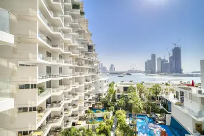 an apartment building with a swimming pool and a city at FIVE Palm Jumeirah Residences - Mint Stay in Dubai