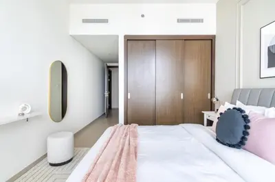 a bedroom with a large white bed with pink pillows at GuestReady - Magnificent heart of Downtown in Dubai