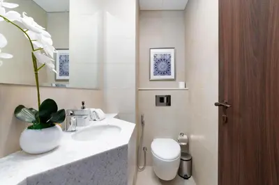 a bathroom with a sink and a toilet and a mirror at Avani Palm Burj-AlArab View from the pool in Dubai