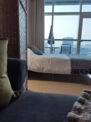 a hotel room with two beds and a large window at Studio in the heart of Sports City -great view & amenities! in Dubai