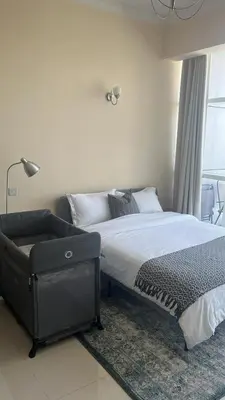 a bedroom with a large bed and a window at Studio in the heart of Sports City -great view & amenities! in Dubai