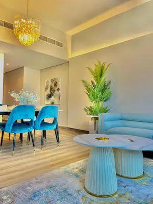 a living room with a blue couch and a table at 2BR Dubai Burj View Downtown Skyline with Pool, Gym, & Parking in Dubai