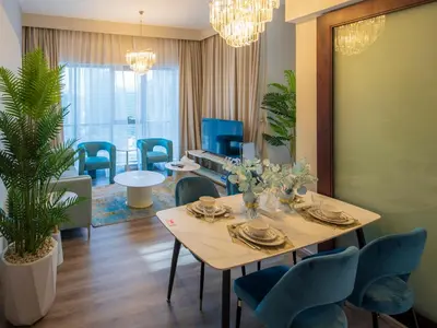 a dining room with a table and chairs at 2BR Dubai Burj View Downtown Skyline with Pool, Gym, & Parking in Dubai