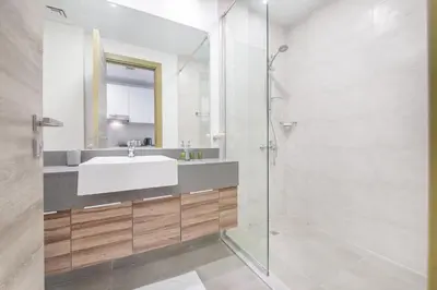 a bathroom with a sink and a glass shower at Apartment on 26th Floor & Beautiful Views (2 adults + 2 kids) in Dubai