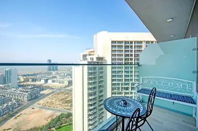 a table and chairs on a balcony with a view of a city at Apartment on 26th Floor & Beautiful Views (2 adults + 2 kids) in Dubai
