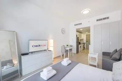 a bedroom with a bed and a living room at Apartment on 26th Floor & Beautiful Views (2 adults + 2 kids) in Dubai