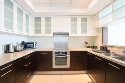 a kitchen with brown cabinets and a sink at HiGuests - Amazing Apartment overlooking Burj Khalifa! in Dubai