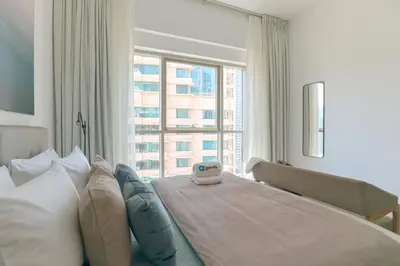 a bedroom with a large bed and a large window at HiGuests - Amazing Apartment overlooking Burj Khalifa! in Dubai