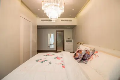 a bedroom with a large bed with a chandelier at Luxurious 2BR - Fully Upgraded - High-end facilities in Dubai