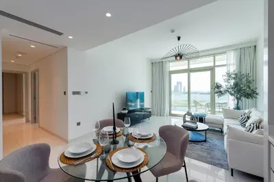 a living room with a glass table and chairs at Sunrise Bay, Emaar Beachfront Dubai Harbour - Mint Stay in Dubai