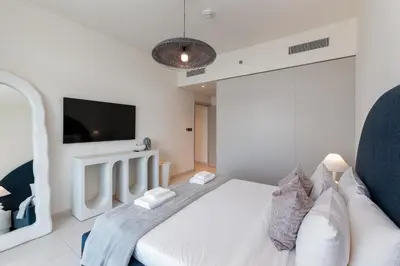 a bedroom with a white bed and a tv at Sunrise Bay, Emaar Beachfront Dubai Harbour - Mint Stay in Dubai