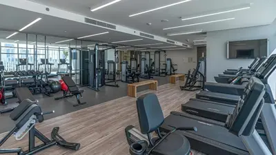 a gym with rows of treadmills and machines at Sunrise Bay, Emaar Beachfront Dubai Harbour - Mint Stay in Dubai