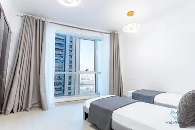 a bedroom with two beds and a large window at Modern 2BR in the Heart of Dubai Marina in Dubai