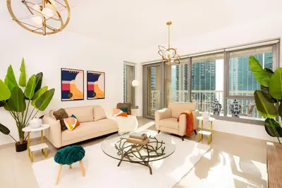 a living room with a couch and chairs and windows at Prime Retreats - 29 Emaar Boulevard Downtown Dubai in Dubai