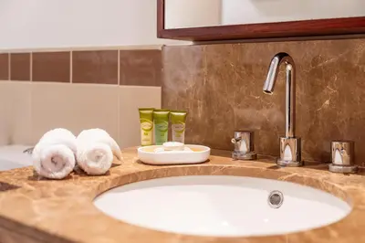 a bathroom counter with a sink and towels at Prime Retreats - 29 Emaar Boulevard Downtown Dubai in Dubai
