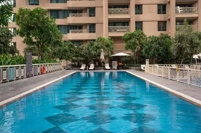 a large blue swimming pool in front of a building at Prime Retreats - 29 Emaar Boulevard Downtown Dubai in Dubai