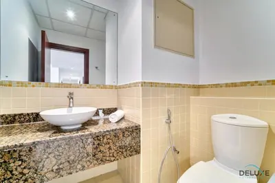 a bathroom with a sink and a toilet and a mirror at Impeccable 2BR at Bahar 2 JBR by Deluxe Holiday Homes in Dubai