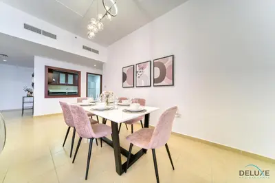 a dining room with a white table and pink chairs at Impeccable 2BR at Bahar 2 JBR by Deluxe Holiday Homes in Dubai