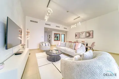 a living room with a couch and a tv at Impeccable 2BR at Bahar 2 JBR by Deluxe Holiday Homes in Dubai