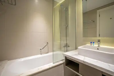 a bathroom with a tub and a sink and a shower at Vacay Lettings - Damac Prive studio in Dubai