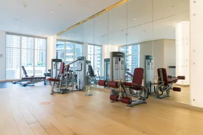 a gym with a large mirror and cardio machines at Vacay Lettings - Damac Prive studio in Dubai