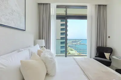 a bedroom with a bed with a view of the ocean at HiGuests - Superlative apt with private beach access in Dubai