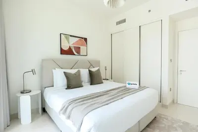 a white bedroom with a large white bed in it at HiGuests - Superlative apt with private beach access in Dubai