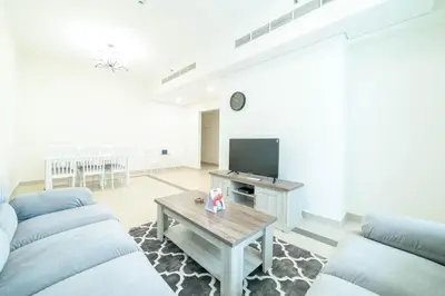 a living room with two couches and a tv at OYO 589 Najma Tower, Two bedrooms Apartments, Sports City in Dubai