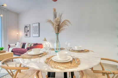 a dining room with a table with chairs and a vase at Rustic 2BR at Sparkle Tower 1 Dubai Marina by Deluxe Holiday Homes in Dubai