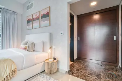 a bedroom with a large bed and a wooden door at Rustic 2BR at Sparkle Tower 1 Dubai Marina by Deluxe Holiday Homes in Dubai