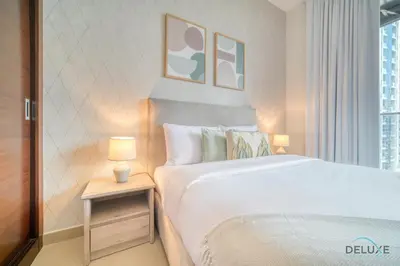 a bedroom with a white bed and a table with a lamp at Rustic 2BR at Sparkle Tower 1 Dubai Marina by Deluxe Holiday Homes in Dubai